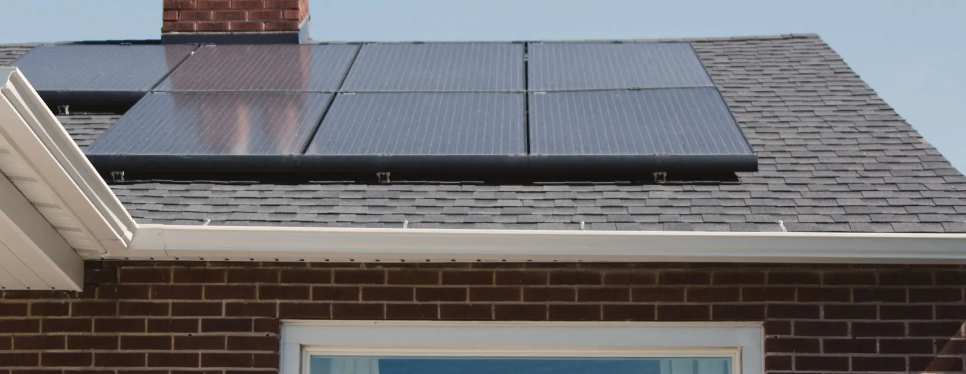 Close-up view of solar panels mounted on a tiled house roof.