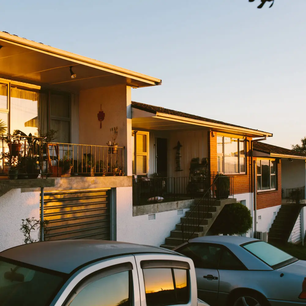 A row of connected townhouses lit by warm evening sunlight.