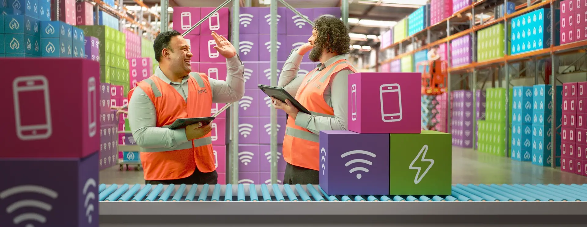 Two warehouse workers using tablets beside a conveyor belt in a distribution warehouse.