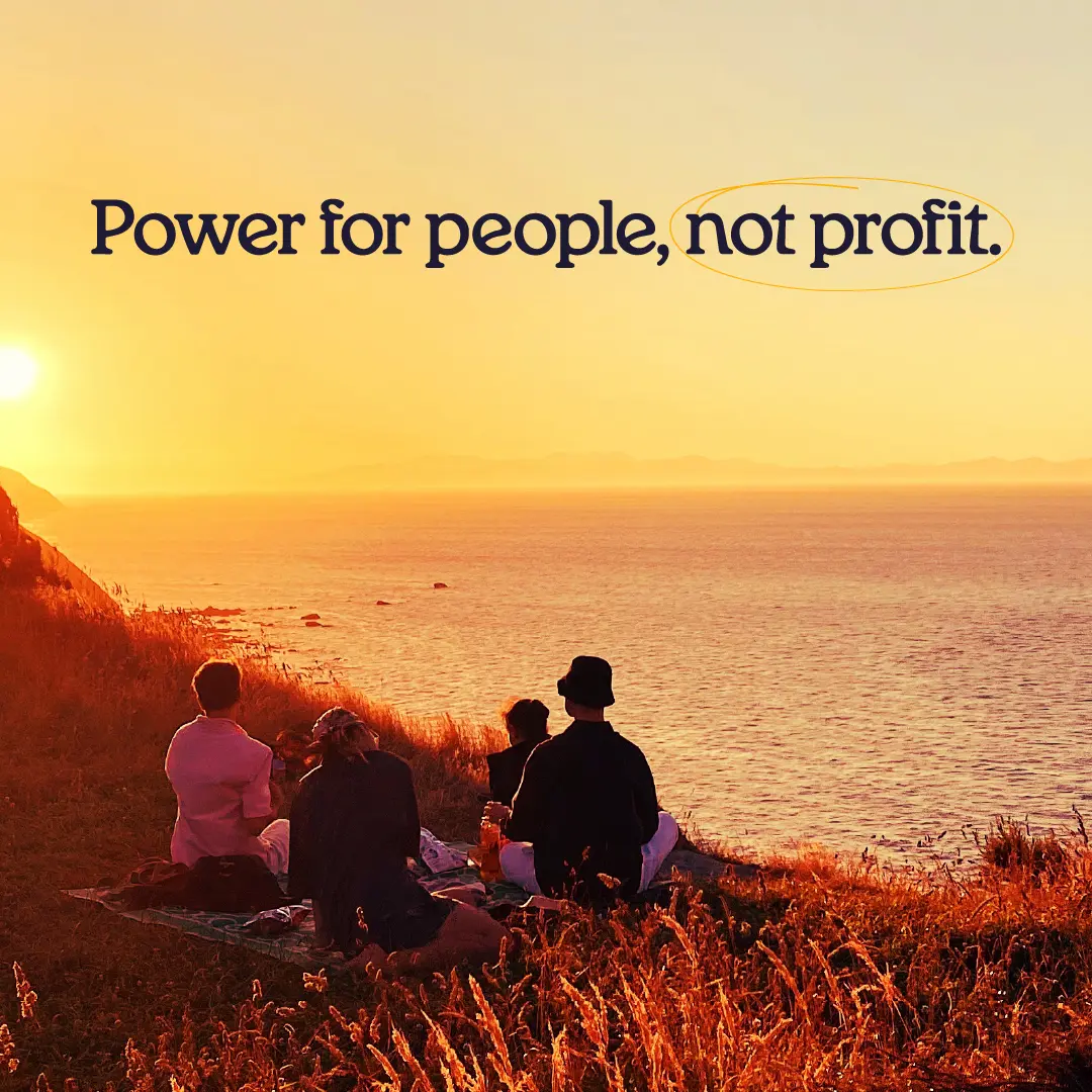 Four people sitting on a hillside at sunset, looking out over the ocean, with the text ‘Power for people, not profit.'